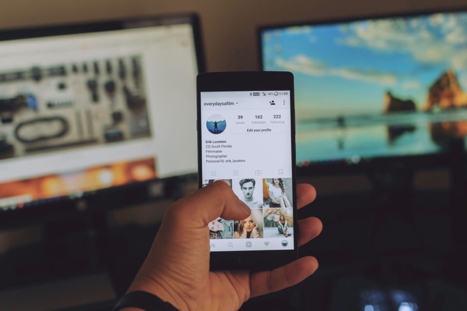 an image from the perspective of someone holding a smart phone. Instagram is on the phone's display.