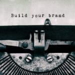 An image of a type writer that has typed "Build your brand."