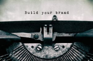 An image of a type writer that has typed "Build your brand."